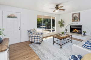 Living room with ceiling fan and light hardwood / wood-style floors