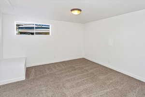 Carpeted empty room featuring a textured ceiling