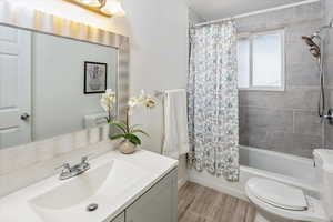 Full bathroom with vanity, toilet, and shower / bath combo with shower curtain