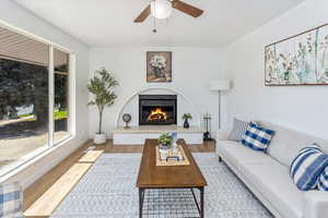 Living room with ceiling fan and light hardwood / wood-style floors