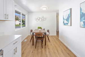 Dining space featuring a textured ceiling and light hardwood / wood-style flooring