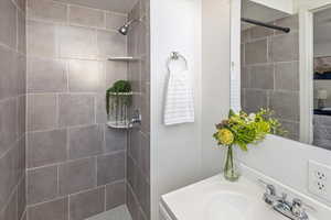 Bathroom with vanity and tiled shower