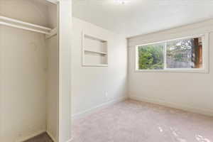 Unfurnished bedroom featuring light carpet and a textured ceiling