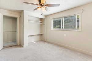 Unfurnished bedroom with multiple windows, light carpet, and ceiling fan