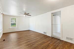 Spare room featuring ceiling fan and dark hardwood / wood-style flooring