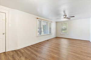 Unfurnished room with wood-type flooring, ceiling fan, and a healthy amount of sunlight