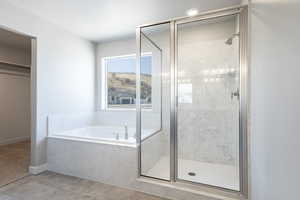 Bathroom featuring shower with separate bathtub and tile patterned floors