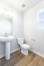 Bathroom featuring toilet, sink, and hardwood / wood-style floors