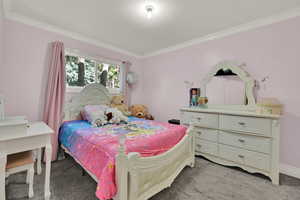 Bedroom with ornamental molding and carpet floors