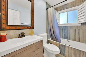 Full bathroom with vanity, toilet, and shower / bath combination with curtain