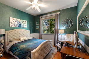 Bedroom with ceiling fan and wood-type flooring