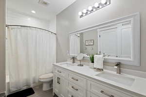 Full bathroom featuring vanity, toilet, and shower / tub combo with curtain