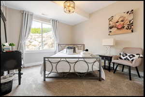 Bedroom with carpet floors and an inviting chandelier