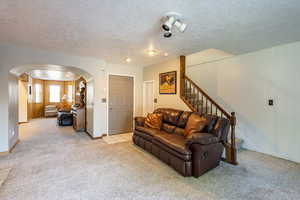 Carpeted living room featuring a textured ceiling