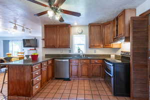 Kitchen with appliances with stainless steel finishes, kitchen peninsula, sink, and plenty of natural light