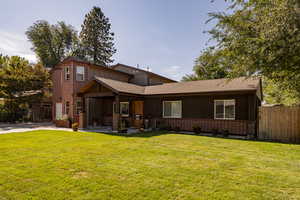 Back of property with a lawn and a patio