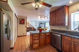 Kitchen featuring a textured ceiling, kitchen peninsula, stainless steel appliances, and plenty of natural light