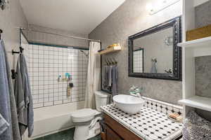 Full bathroom with tile patterned flooring, shower / bath combo, vanity, and toilet