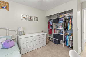 Bedroom with a closet, a textured ceiling, and light colored carpet