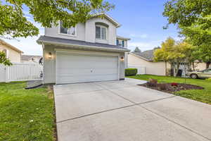 View of front property featuring a front yard and a garage