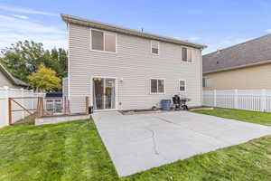 Rear view of house with a lawn and a patio area