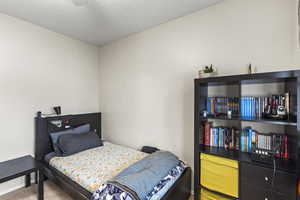 Bedroom with a textured ceiling and carpet flooring