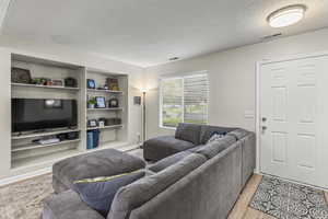 Living room featuring light hardwood / wood-style flooring and a textured ceiling