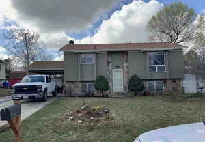 Bi-level home with a front yard and a carport