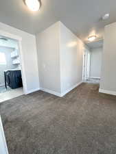 Spare room with a textured ceiling and light colored carpet