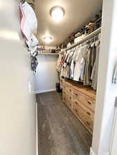 Walk in closet with dark colored carpet