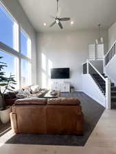 Living room featuring a high ceiling, ceiling fan, and hardwood / wood-style flooring