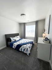 Carpeted bedroom with a textured ceiling