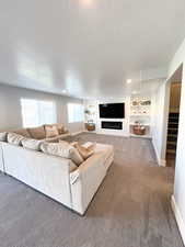 Carpeted living room featuring a textured ceiling and built in features