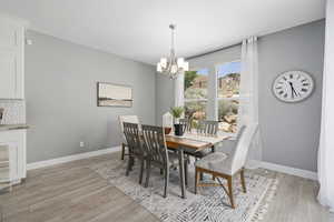 Dining room with a notable chandelier and light wood-type flooring