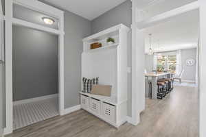 Mudroom with an inviting chandelier and light wood-type flooring