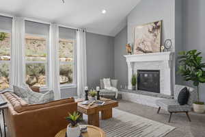 Carpeted living room featuring a fireplace and vaulted ceiling