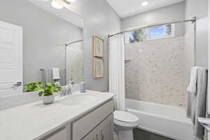 Full bathroom featuring tile patterned floors, toilet, vanity, and shower / bathtub combination with curtain