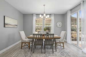 Dining space with a notable chandelier and hardwood / wood-style floors