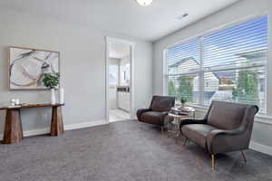 Living area featuring light carpet and a textured ceiling