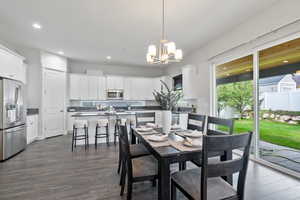 Dining area featuring a notable chandelier and dark hardwood / wood-style flooring