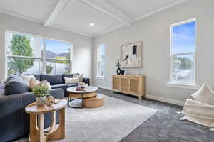 Carpeted living room with beam ceiling and plenty of natural light