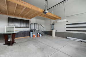 Garage featuring a garage door opener and a wall mounted air conditioner