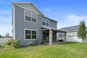 Rear view of house featuring a yard and a patio