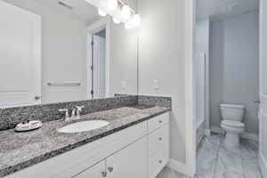 Bathroom featuring vanity, toilet, and a tub