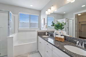 Bathroom featuring vanity and independent shower and bath