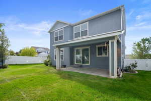 Back of property featuring a patio area and a lawn