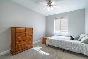 Carpeted bedroom featuring ceiling fan