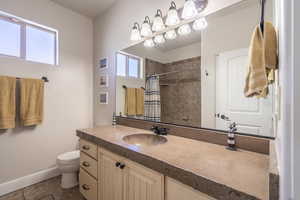 Bathroom featuring plenty of natural light, tile patterned flooring, toilet, and vanity