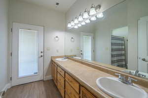 Bathroom featuring walk in shower, hardwood / wood-style flooring, vanity, and toilet