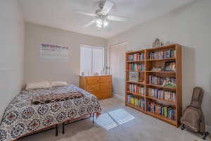 Bedroom with light colored carpet and ceiling fan